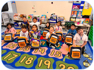 Young children in OUSD's 2023 Summer Kinder Bridge program sit on a colorful carpet with their backpacks from First 5 Alameda County